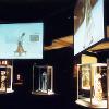 Central space with large videos on suspended projection screens